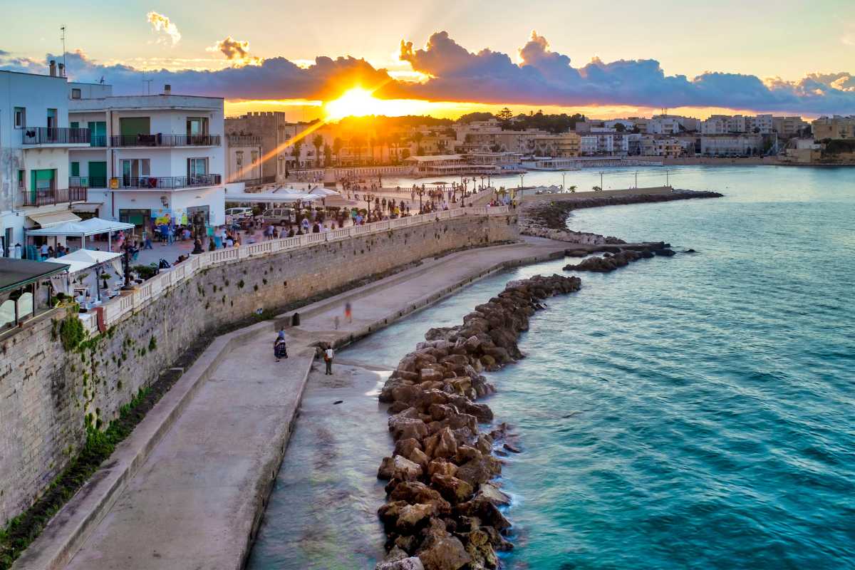 Paesaggio costiero di Otranto con sentiero panoramico, mare azzurro e vegetazione mediterranea, cielo limpido, luce del mattino