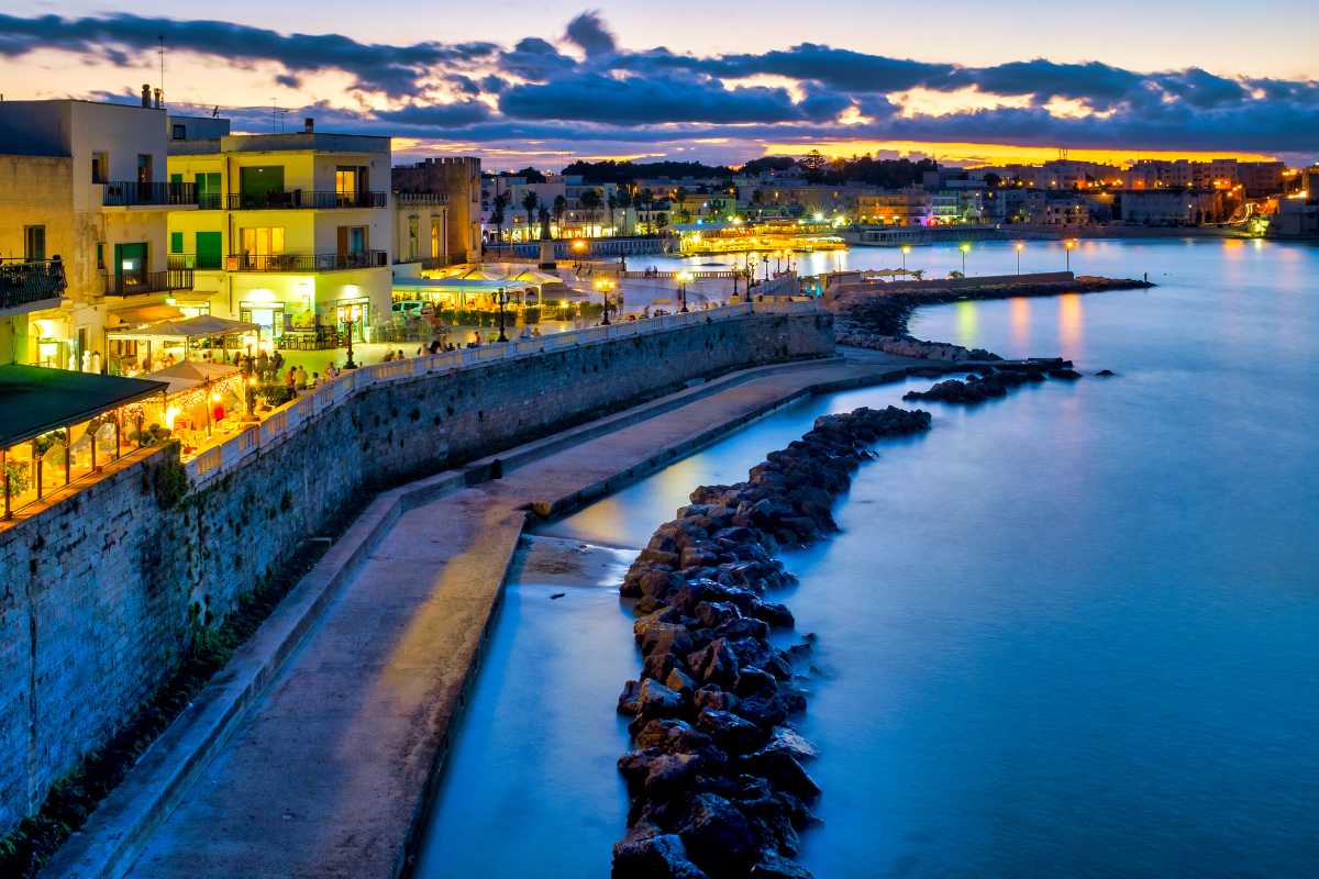 Scorcio panoramico del centro storico di Otranto al tramonto, mura aragonesi, vicoli illuminati e vista sul mare Adriatico